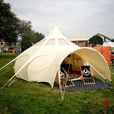 Picture of a Lotus Belle Tent pitched in a field. A luxury, canvas bell tent, but with lots of standing room. Perfect for glamping, events & parties